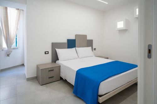een slaapkamer met een groot bed met een blauwe deken bij Nonna Anna in Castellammare di Stabia