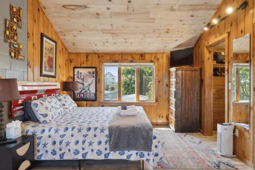 a bedroom with a bed in a room with wooden walls at Basin Perch Basin Views Sunsets AC Deck in Plum Island
