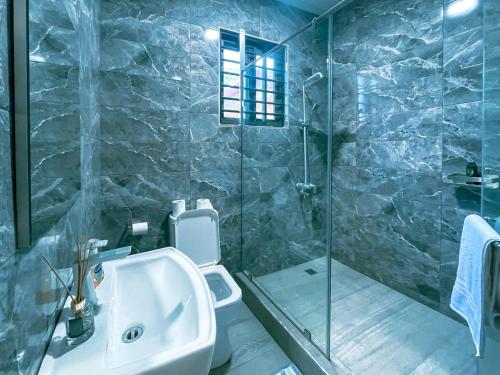 une salle de bain avec un lavabo et une douche en verre dans l'établissement Maryland House in Com 20 Tema Greater Accra Ghana, à Kwedonu