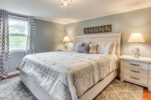 a bedroom with a bed and two lamps and a window at Private Hot Tub Cottage Near Hikes and Pigeon River in Canton