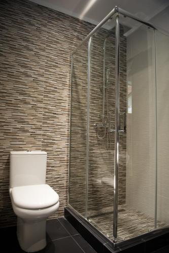 a bathroom with a toilet and a glass shower at Serenita Apartments in Ermones