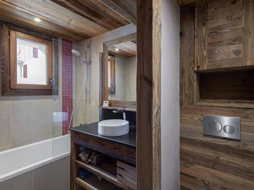 ein Badezimmer mit Waschbecken und Spiegel in der Unterkunft Appartement neuf et spacieux, idéal pour familles, proche des pistes et calme montagnard - FR-1-570-14 in Levassaix