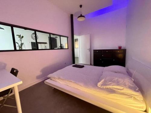 une chambre avec un lit, une commode et une table dans l'établissement Loft industriel en centre ville, au Puy-en-Velay