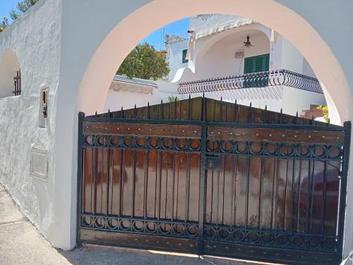 a gate in front of a white house with an arch at Elegante Villa al centro di Ischia Porto in Ischia