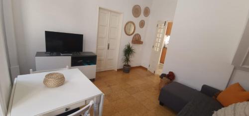a living room with a couch and a tv at Casa Pisa Flores - Praia da Nazaré in Nazaré