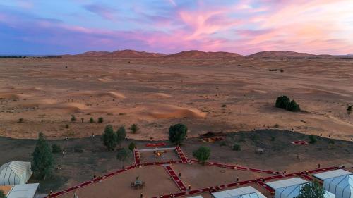 an aerial view of a desert with a building in the foreground at Arabian Nights Desert Camp Merzouga in Lac Yasmins