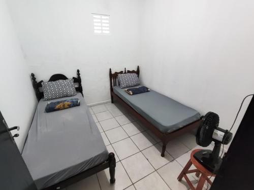 a room with two beds and a television in it at Ap 2 quartos com vaga de garagem in Campina Grande
