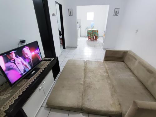 a living room with a tv on a counter at Ap 2 quartos com vaga de garagem in Campina Grande