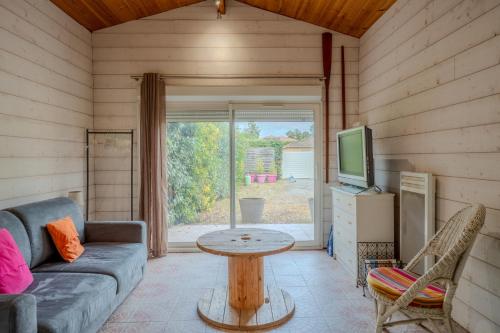 un salon avec un canapé, une télévision et une table dans l'établissement Studio avec terrasse pour 2 personnes à Andernos, à Andernos-les-Bains