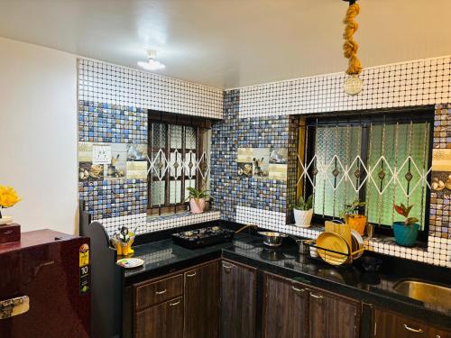 a kitchen with blue and white tiles on the wall at Hidden Gem agonda in Agonda