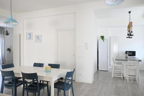 a white dining room with a white table and chairs at S270 - Sirolo, quadrilocale in centro con vista panoramica in Sirolo