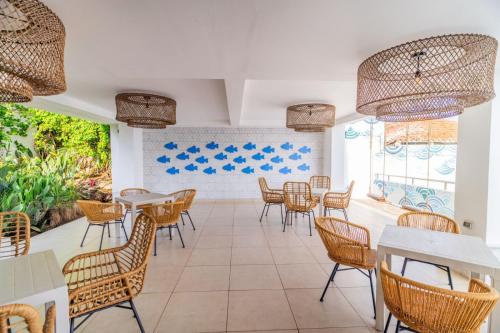 a restaurant with chairs and tables and windows at Hotel Los Farallones in La Libertad