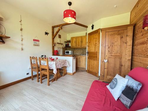 une cuisine et une salle à manger avec une table et des chaises dans l'établissement Studio skis aux pieds, animaux acceptés, parking, balcon, 4 personnes - FR-1-505-230, à Notre-Dame-de-Bellecombe