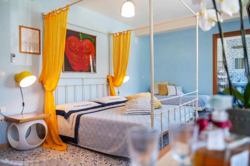 a bedroom with a canopy bed with yellow curtains at Hotel Ristorante Cavaliere in Scario