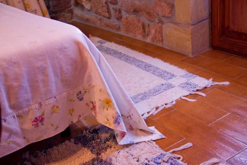 a bedroom with a bed and a rug on the floor at Casa Velarde in Torrelavega