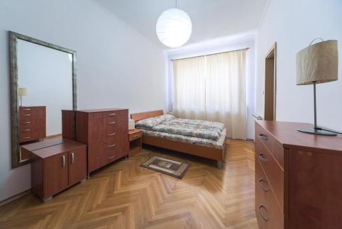 1 dormitorio con cama, tocador y espejo en Apartment Kruna Center, en Podgorica