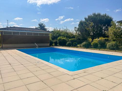 une piscine avec de l'eau bleue dans une cour dans l'établissement Appartement Lumineux Avec Balcon et piscine, à Les Billaux