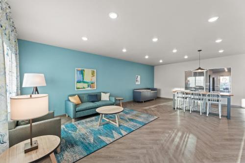a living room and dining room with a blue wall at WoodSpring Suites Jackson Pearl I-20 in Pearl