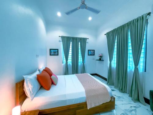 une chambre avec un lit avec des murs et des fenêtres bleus dans l'établissement Maryland House in Com 20 Tema Greater Accra Ghana, à Kwedonu