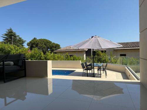 a patio with a table and chairs and an umbrella at Panoramic Montain in Cabrils