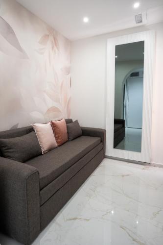 a living room with a couch and a mirror at Th Luxury Apartment Taormina in Taormina