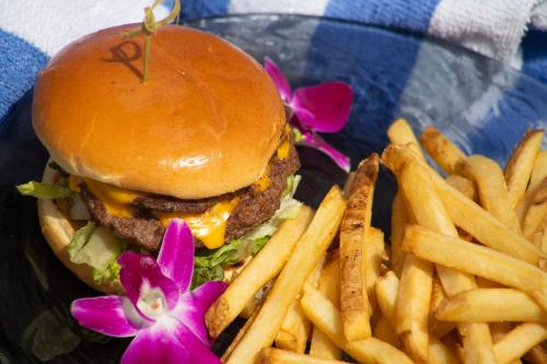 a burger and french fries on a plate with a flower at B Ocean Resort Fort Lauderdale Beach in Fort Lauderdale