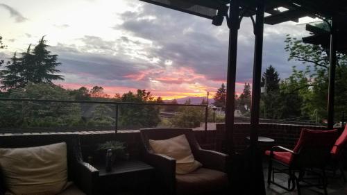 a view of a sunset from a patio with a couch at Shaughnessy Heritage Manor on Vancouver's Westside free housekeeping optional in Vancouver