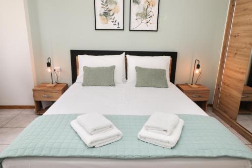 Un dormitorio con una cama grande con toallas. en Xenia's cozy spot, en Volos