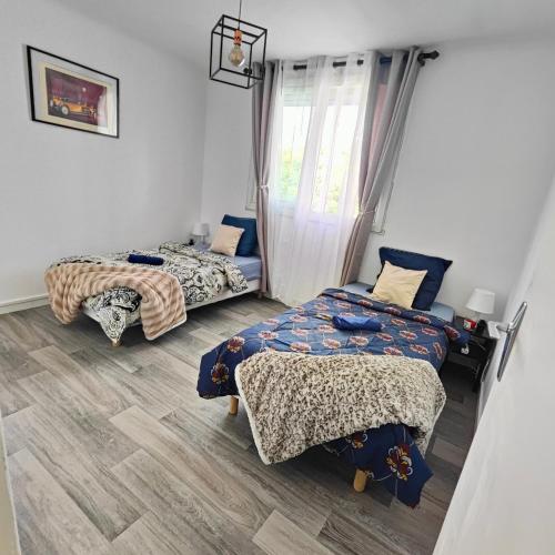 une chambre avec deux lits et une fenêtre dans l'établissement Appartement Montpellier sud ,F3 calme et reposant, à Montpellier