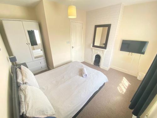 a bedroom with a bed with a fireplace and a tv at 4-5 Bedroom House For Corporate Stays in Kettering in Kettering