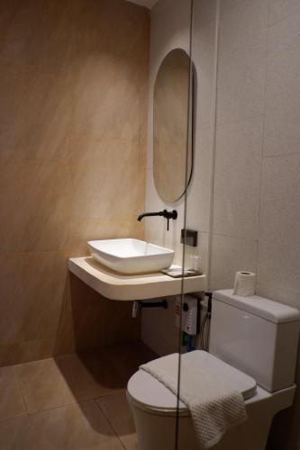 a bathroom with a sink and a toilet and a mirror at Sunvada Beach Rayong in Rayong