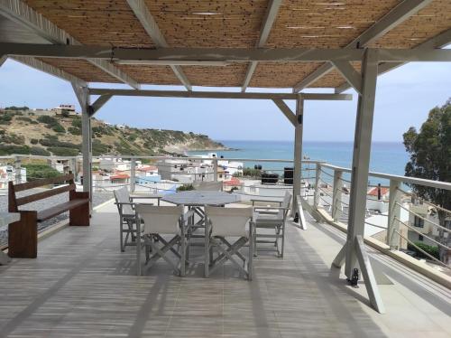 a patio with a table and chairs and the ocean at Alkinoi studio suita in South Crete Tsoutsouros in Tsoútsouros