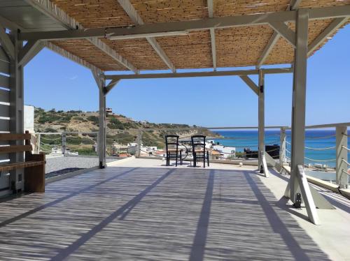 a wooden deck with a view of the ocean at Alkinoi studio suita in South Crete Tsoutsouros in Tsoútsouros