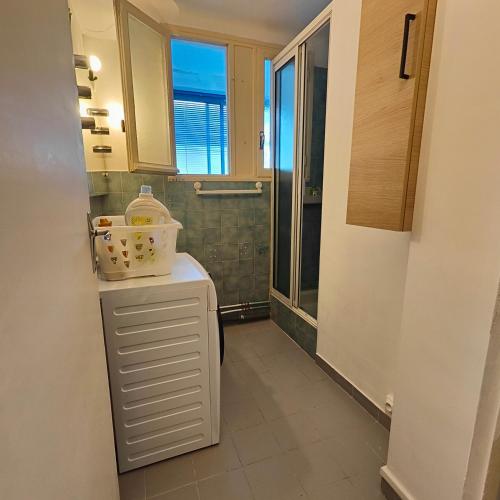 Elle comprend une petite cuisine avec un réfrigérateur et une fenêtre. dans l'établissement Appartement Montpellier sud ,F3 calme et reposant, à Montpellier