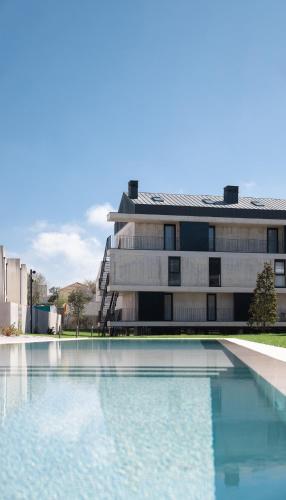 un edificio con piscina en frente de un edificio en Sunny Duplex with Pool and Ofir Beach Nature Escape, en Fão