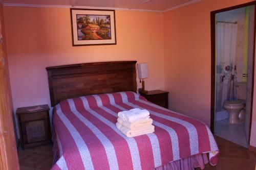 a bedroom with a bed with a pile of towels on it at Hostal Atacama North in San Pedro de Atacama