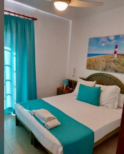 a bedroom with a large bed with a blue curtain at Costa Mernorca in Son Xoriguer