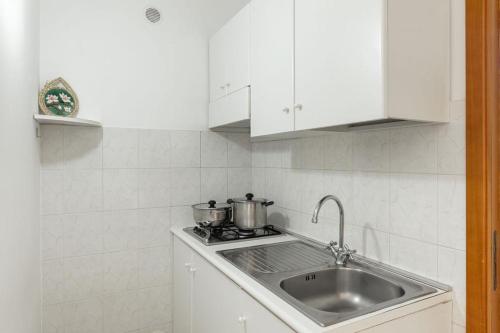 un évier de cuisine avec deux casseroles sur une cuisinière dans l'établissement Residence Camping Atlantide, à Faccia di Trippa