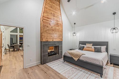 een slaapkamer met een bed en een open haard bij The Echo - Forest Romance with Sunken Hot Tub Underneath the Starlit Night in Broken Bow