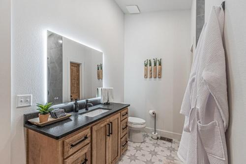 een badkamer met wastafel en toilet bij The Echo - Forest Romance with Sunken Hot Tub Underneath the Starlit Night in Broken Bow