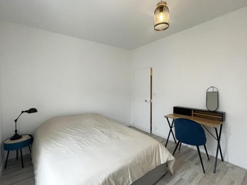 a white bedroom with a bed and a desk and a lamp at Charming Cozy Cottage Palaiseau Center in Palaiseau