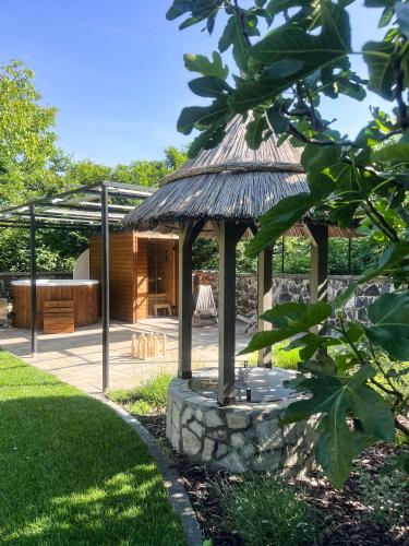 a gazebo with a thatch roof at Zanzara Guesthouse in Pákozd