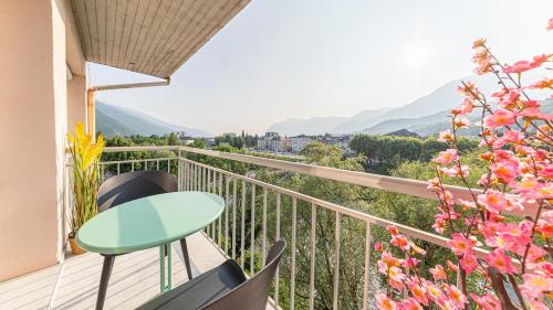 a balcony with a table and chairs and mountains at Le Beauregard - Jacuzzi - Garage in Albertville