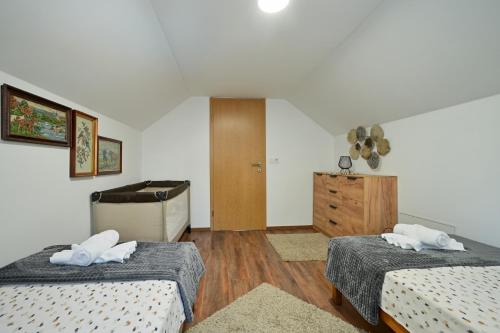a hotel room with two beds and a dresser at Kuća za odmor Zora in Bregi Radobojski