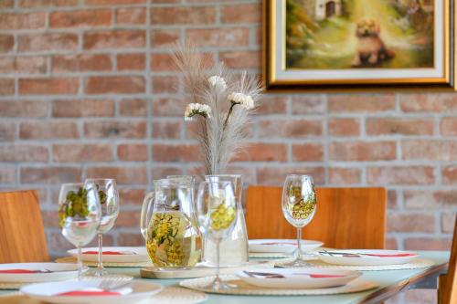 a table with wine glasses and flowers on it at Kuća za odmor Zora in Bregi Radobojski