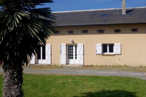 une maison avec des fenêtres blanches et un palmier dans l'établissement House with garden by the sea No 2, à Ouistreham