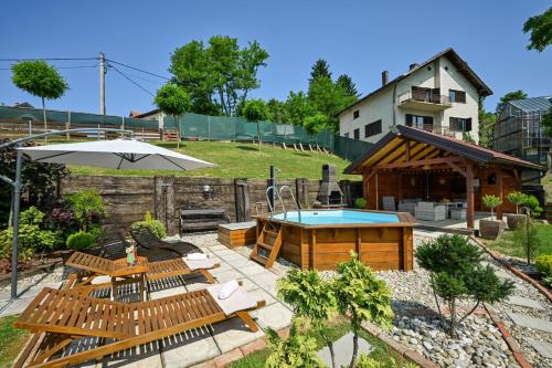 a backyard with a pool and benches and an umbrella at Kuća za odmor Zora in Bregi Radobojski