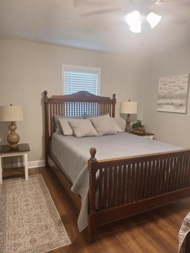 a bedroom with a large wooden bed with two lamps at Lakeside Cove Retreat on Lake Conroe - Private Waterfront in Willis