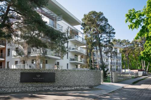 an apartment building with a sign in front of it at HoliApart in Nautikka Park - blisko plaży, kids club, plac zabaw, garaż podziemny in Krynica Morska