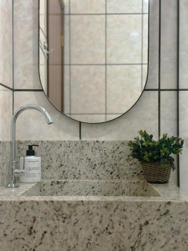 a bathroom counter with a sink with a mirror at Conforto e Estilo - RJ2-05 in Maringá